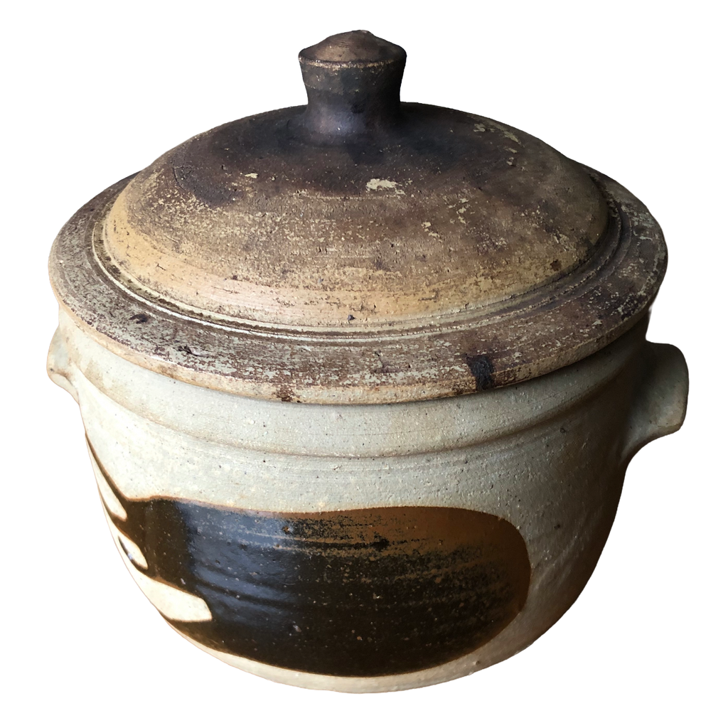 Alan Brough Newlyn Pottery stoneware casserole with domed brown lid, pale buff body and broad dark brown brushwork, on white background.
