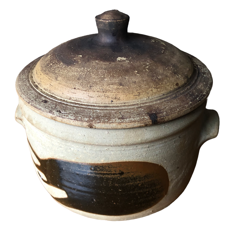 Alan Brough Newlyn Pottery stoneware casserole with domed brown lid, pale buff body and broad dark brown brushwork, on white background.