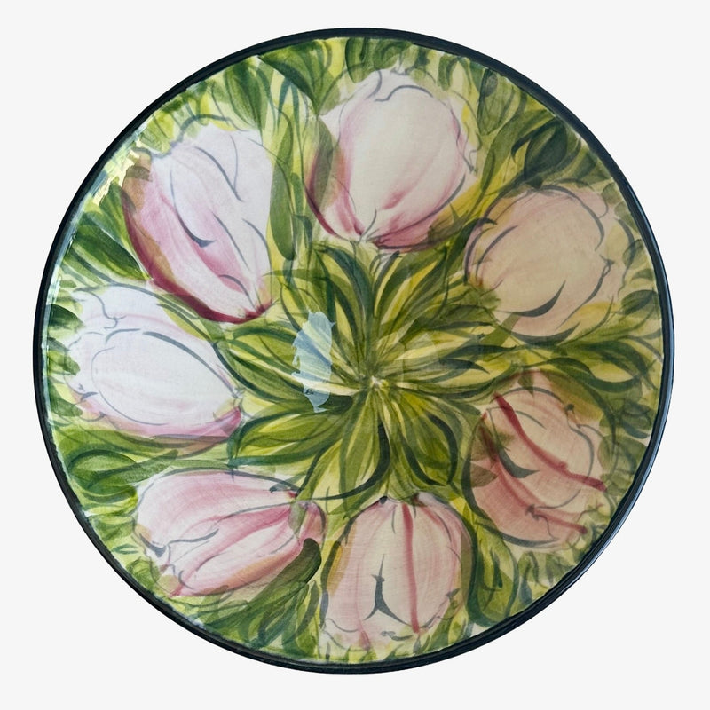 Top-down view of Valerie Shelton ceramic bowl showing freehand-painted pink tulips radiating from centre on green foliage