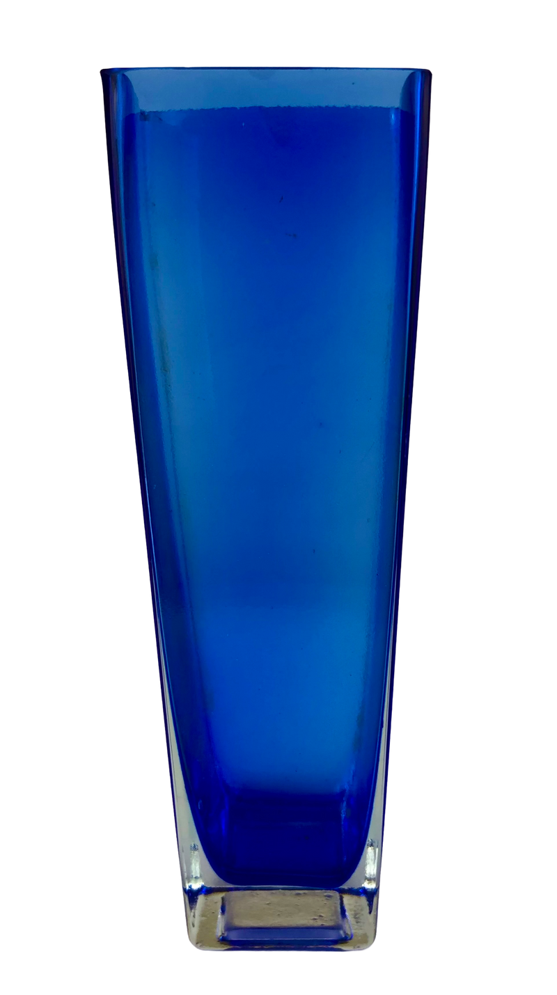 Side view of a vintage Finnish blue glass vase with clear casing and a thick square base.