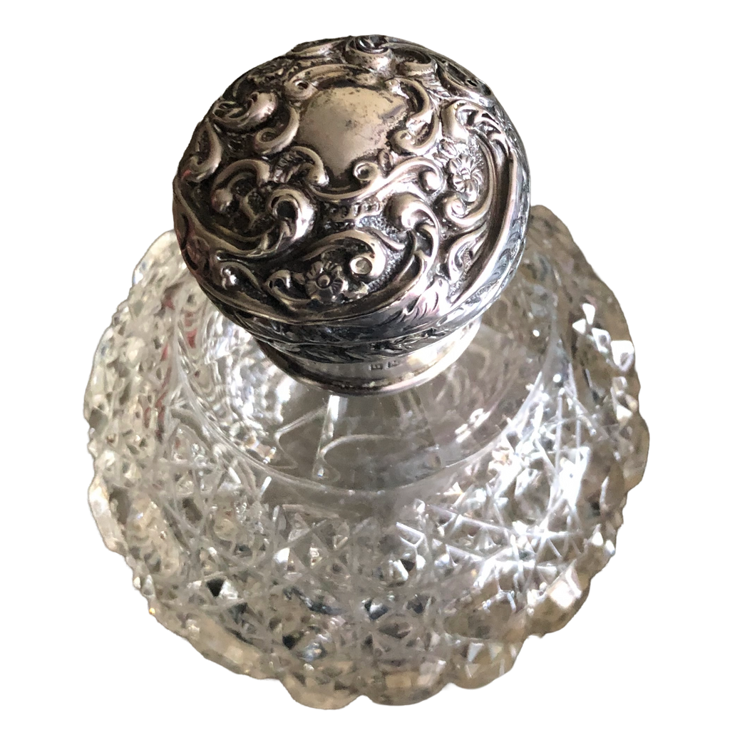 Henry Matthews Victorian scent bottle with hobnail-cut glass body and embossed silver lid decorated with flowers and scrollwork.