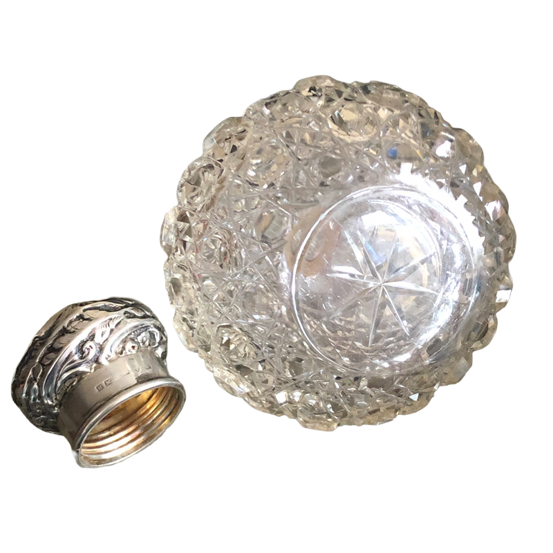 Star-cut base of the Victorian glass scent bottle, with the detached hallmarked silver screw cap beside it.