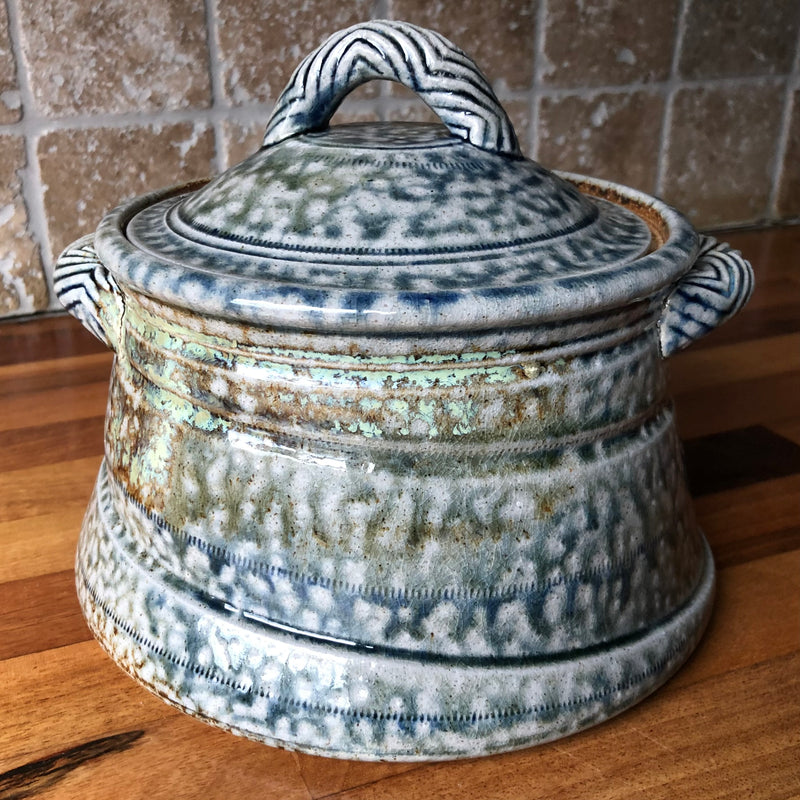 Jane Hamlyn salt-glazed stoneware casserole with mottled blue-grey glaze, fitted lid and chevron-patterned handles.