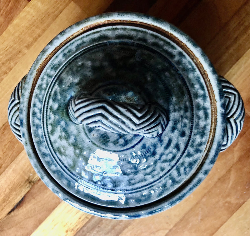 Overhead view of Jane Hamlyn casserole with concentric decoration on the lid and a raised chevron-patterned handle.