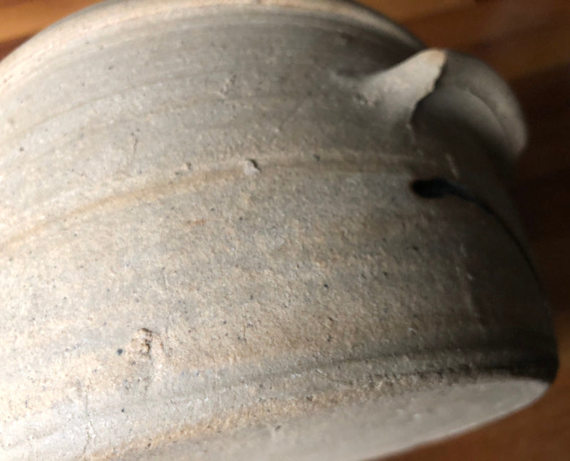 Close-up of Alan Brough stoneware casserole showing the pale speckled clay, horizontal throwing lines and side handle.