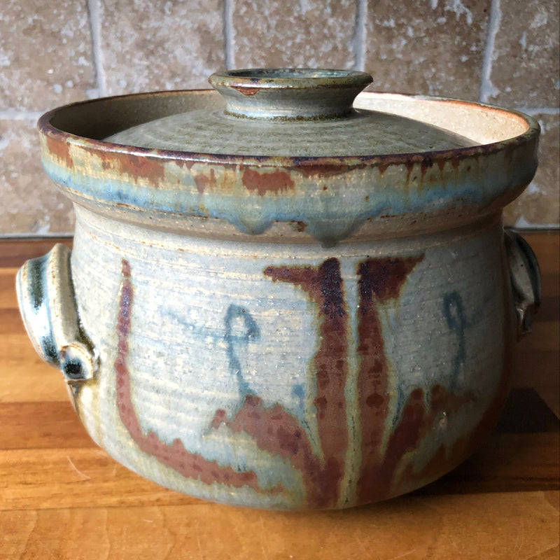 Vera Tollow stoneware casserole with fitted lid, blue-grey and olive glaze, rust-red brushwork and two side handles.