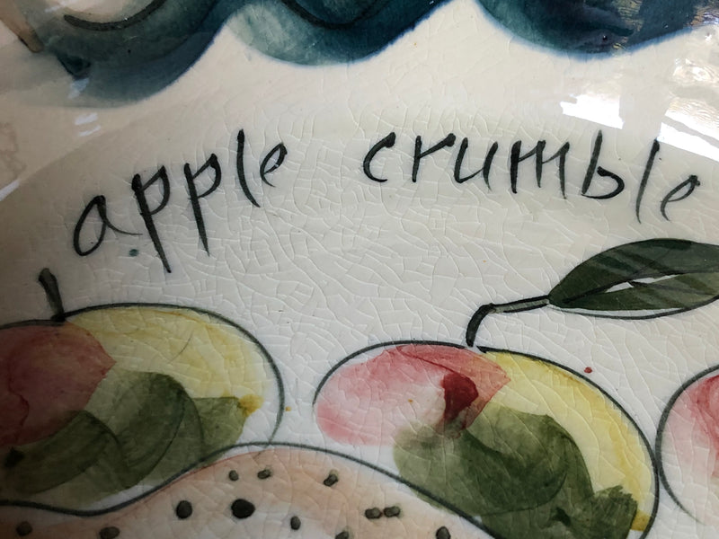 Detail of the apple crumble lettering and painted decoration inside the vintage pottery dish.