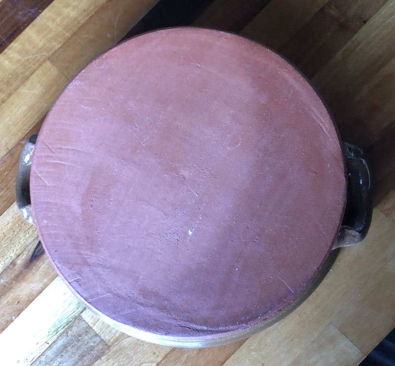 Underside of the apple crumble dish showing its plain, red clay unmarked base.