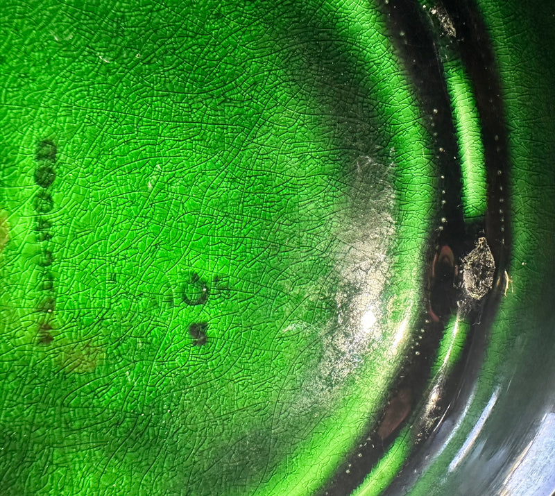 Close-up of translucent green majolica glaze on Victorian Wedgwood Sunflower plate showing pooled deep green tones, circa 1879
