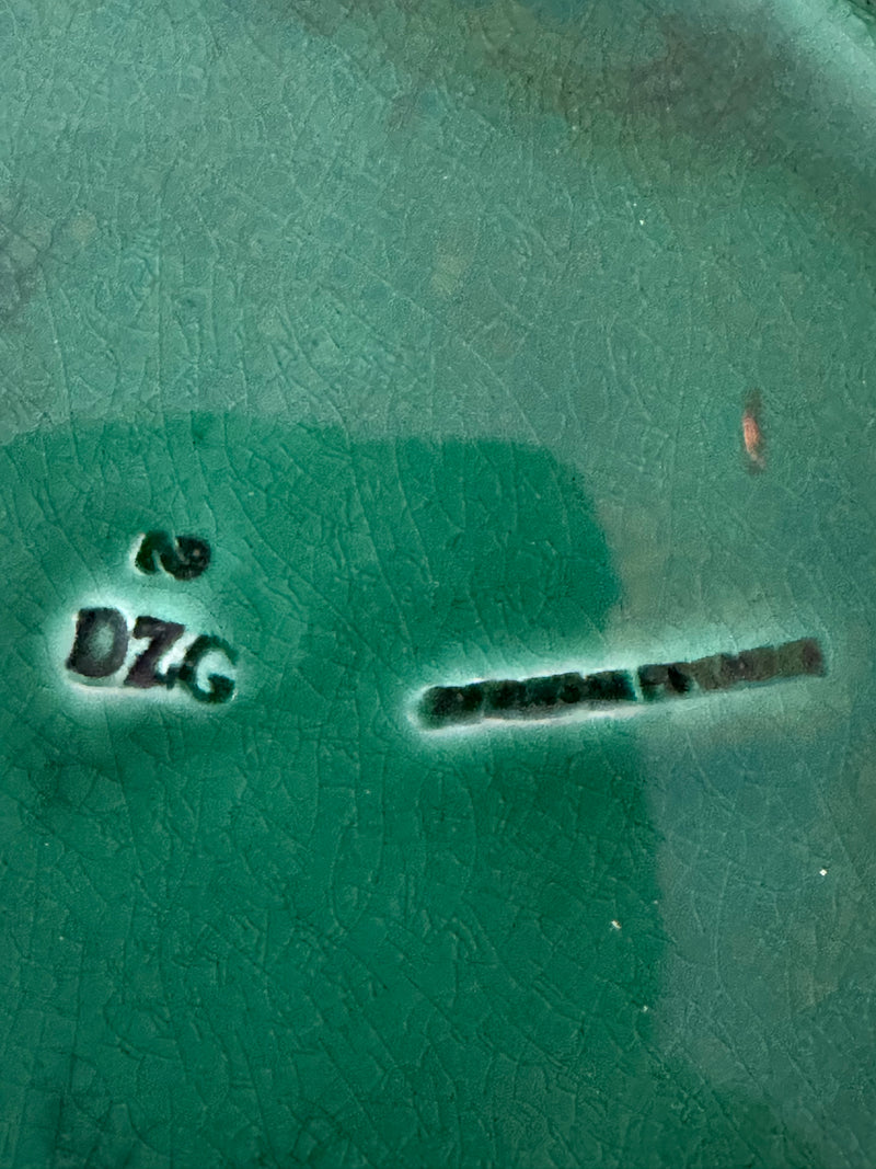 Close-up of translucent green majolica glaze on Victorian Wedgwood Sunflower plate showing pooled deep green tones, circa 1879
