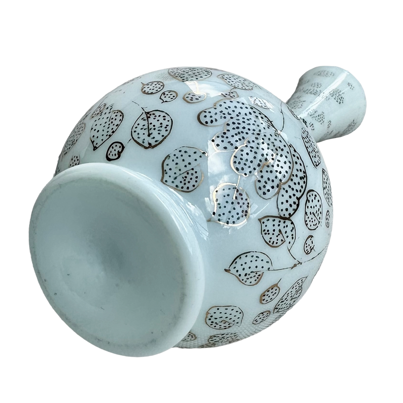 French opaline glass vase lying on its side, showing the recessed base and floral decoration around the body.