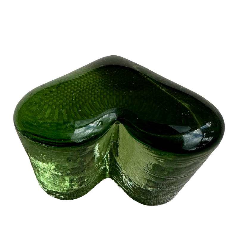 Fire & Light green glass heart paperweight viewed from the lobed end, showing its curved outline and textured sides.
