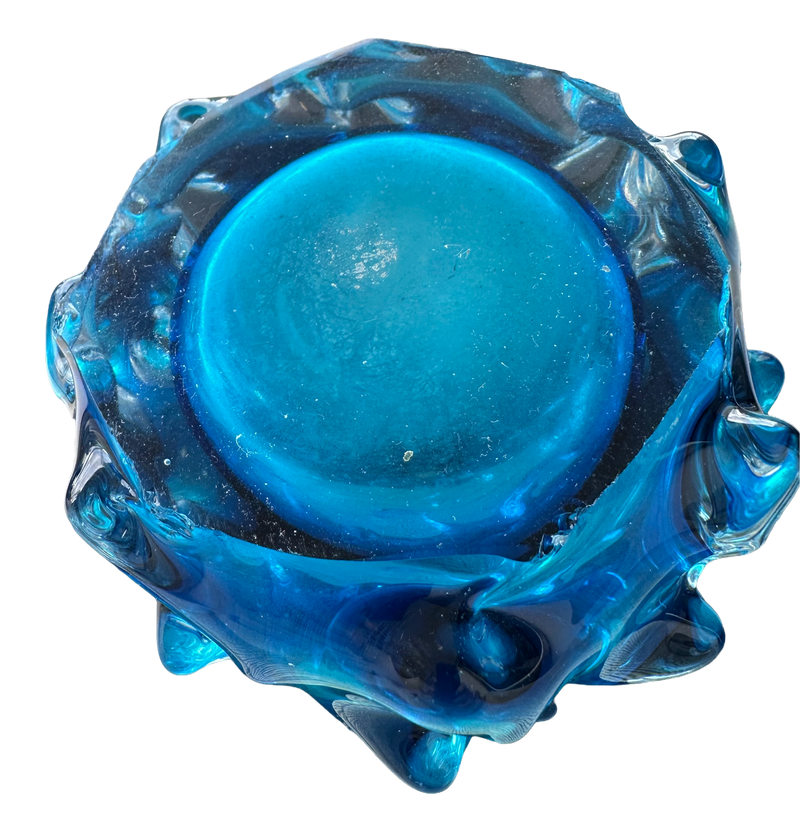 Underside of the Škrdlovice glass vase showing the circular polished base and light surface scratches.