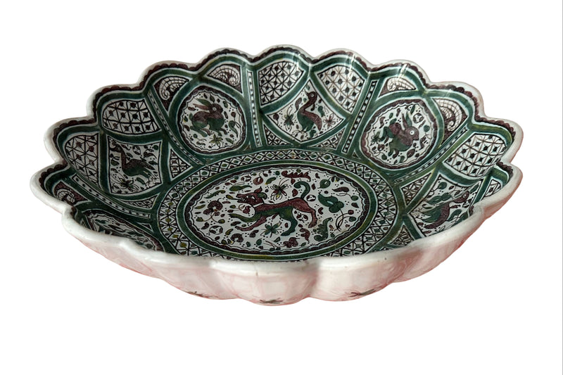 hree-quarter angle, full bowl showing depth Portuguese Coimbra faience centrepiece bowl, three-quarter view showing depth and scalloped rim, hand-painted bestiary panels in green and manganese on cream ground

