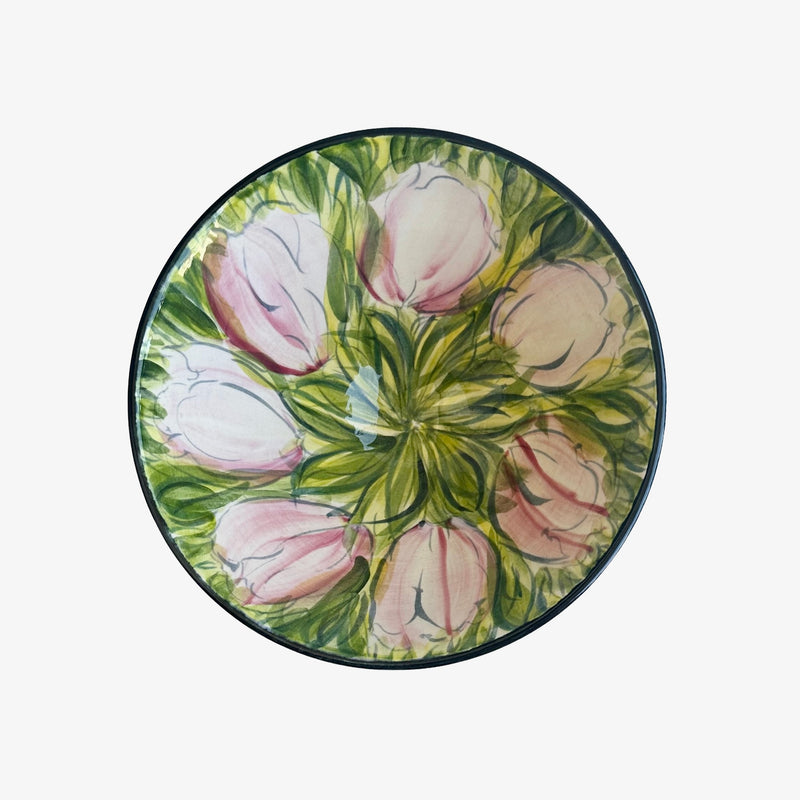 Top-down view of Valerie Shelton ceramic bowl showing freehand-painted pink tulips radiating from centre on green foliage